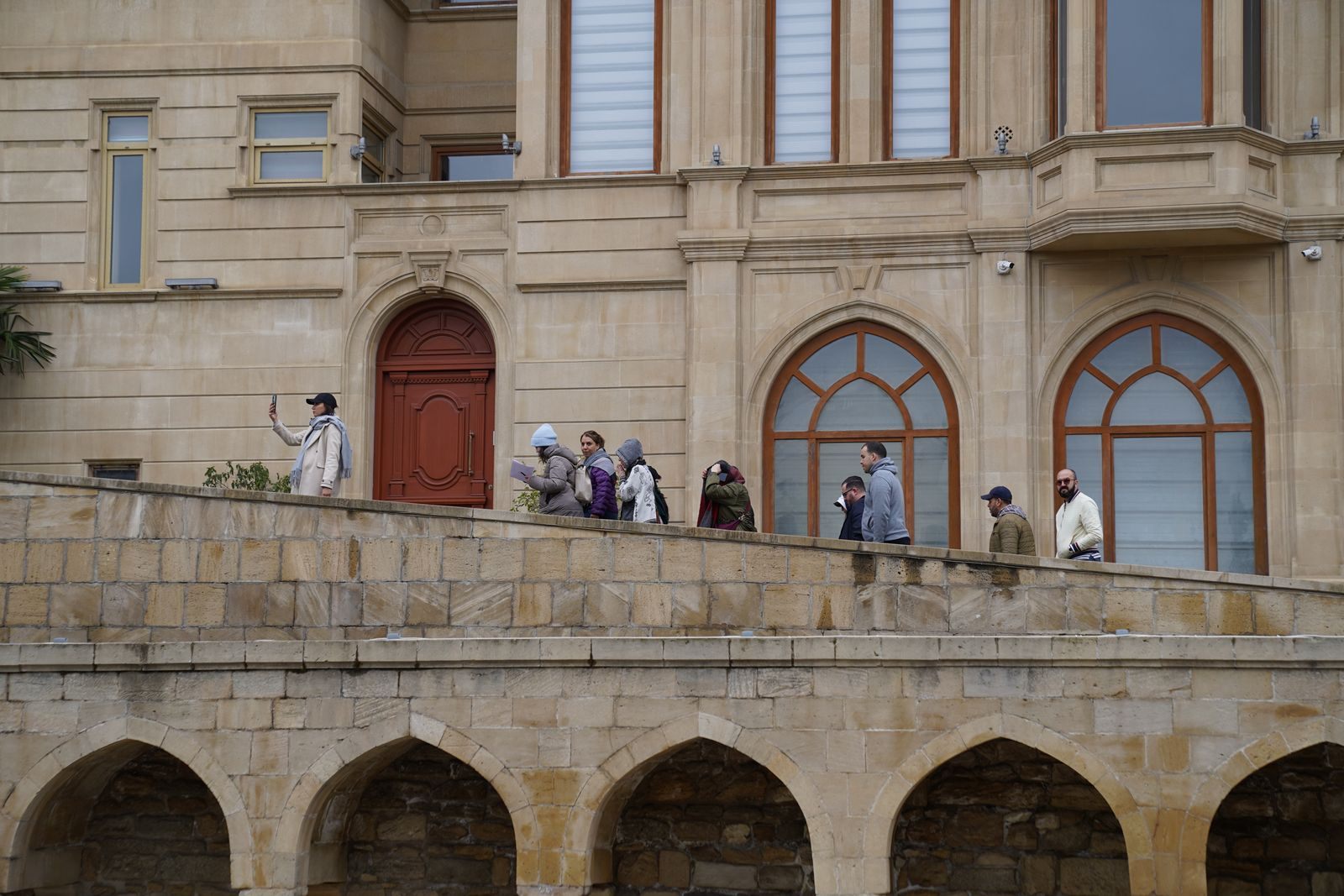 Visitors on a stone terrace of a historic European building, the included kind of tour that shows how to save money on cruise excursions